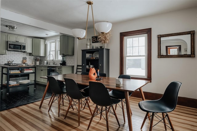 dining area featuring sink and light hardwood / wood-style flooring