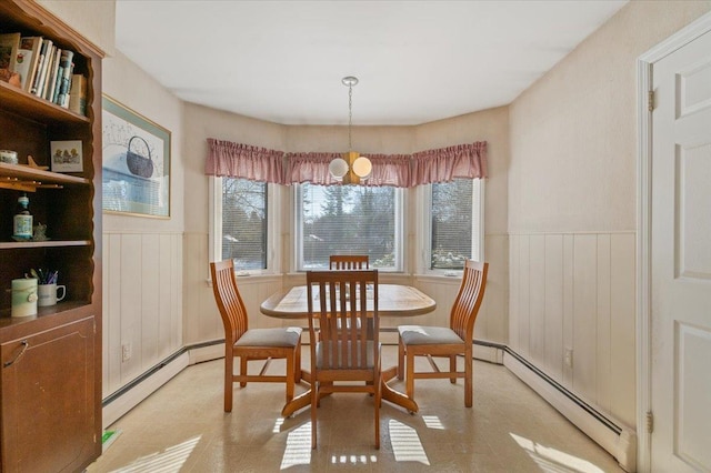 dining space featuring a baseboard radiator and wood walls