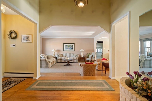 entrance foyer with crown molding, a baseboard radiator, and hardwood / wood-style floors