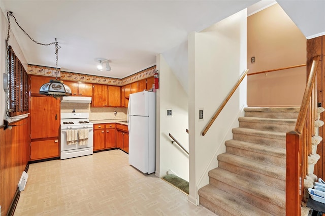 kitchen featuring decorative light fixtures, backsplash, and white appliances