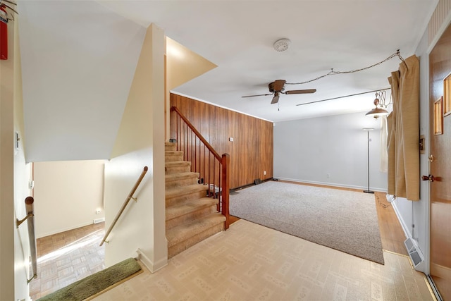 interior space with ceiling fan and wooden walls