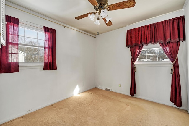 carpeted empty room featuring ceiling fan and plenty of natural light