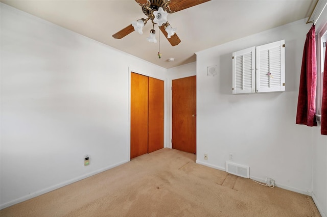 unfurnished bedroom with ceiling fan, light colored carpet, and a closet