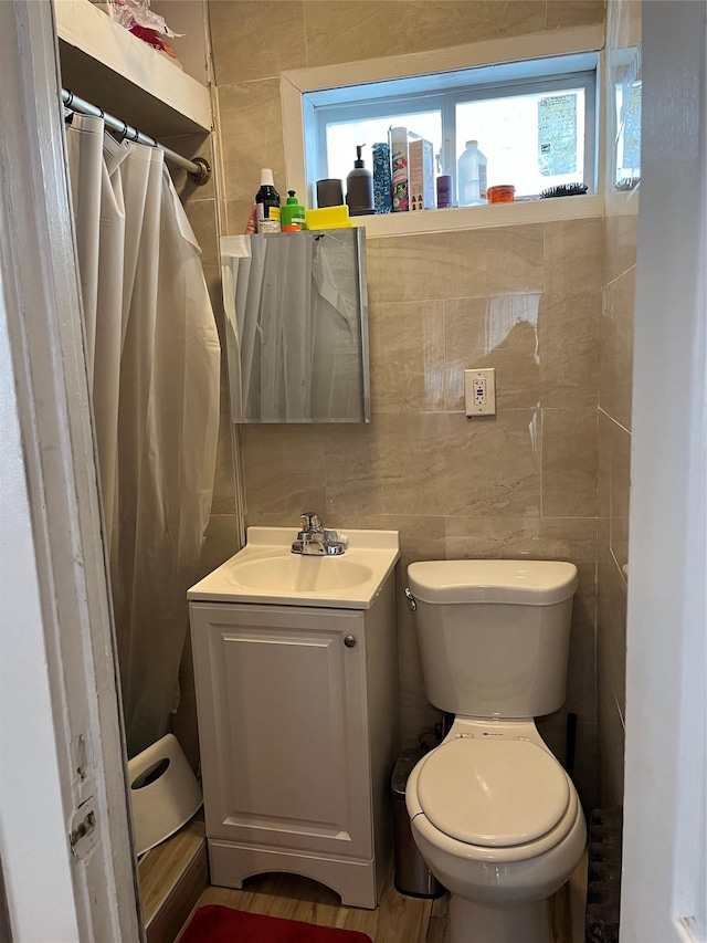 bathroom featuring a wealth of natural light, tile walls, and vanity