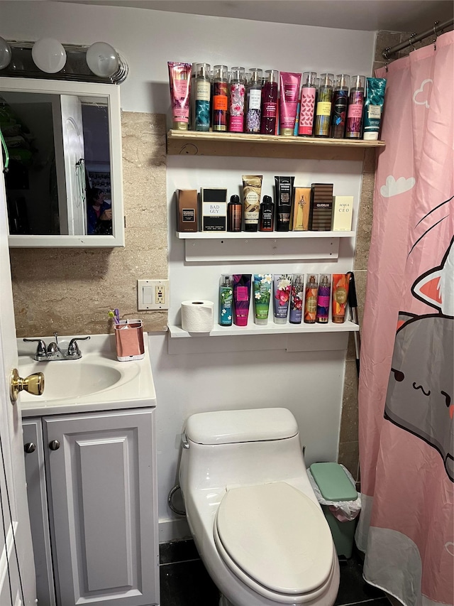 bathroom featuring toilet, backsplash, and vanity