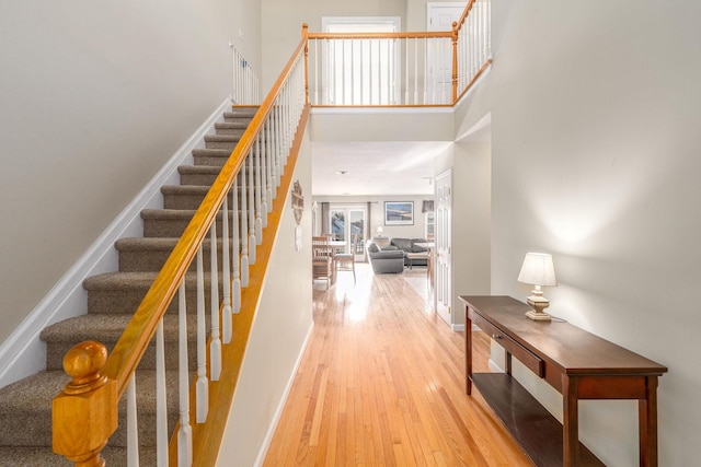 stairway featuring a high ceiling and hardwood / wood-style floors