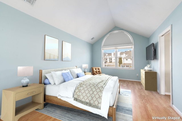 bedroom featuring lofted ceiling and light hardwood / wood-style floors