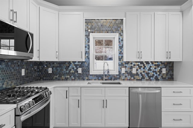 kitchen featuring white cabinetry, sink, backsplash, and appliances with stainless steel finishes