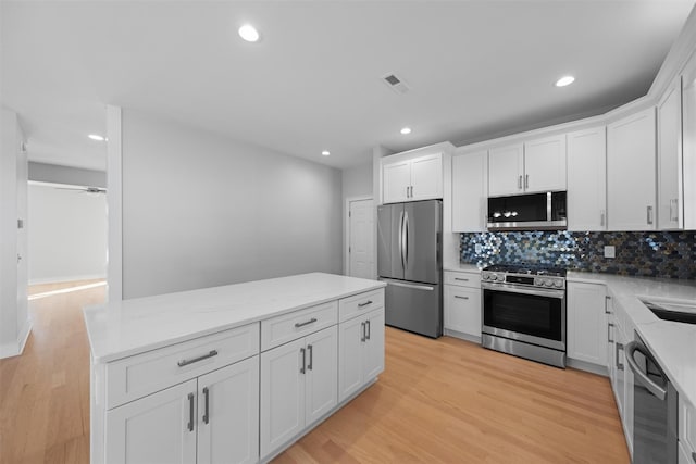 kitchen featuring white cabinetry, stainless steel appliances, and light hardwood / wood-style floors