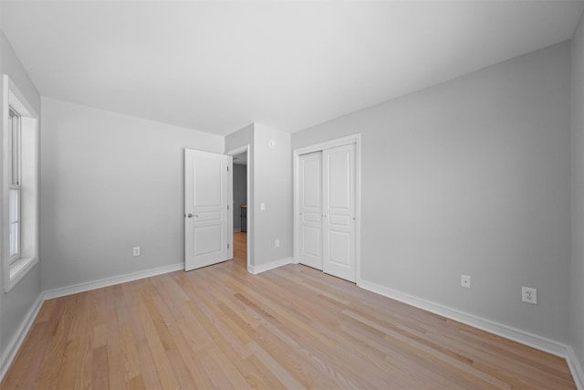 unfurnished bedroom featuring light hardwood / wood-style floors and a closet