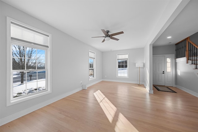 unfurnished living room featuring ceiling fan and light wood-type flooring