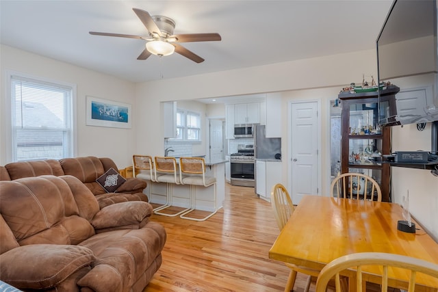 living room featuring ceiling fan and light hardwood / wood-style flooring