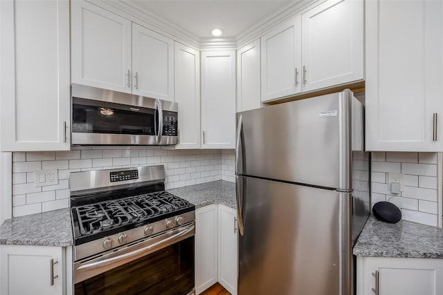 kitchen with stainless steel appliances, backsplash, and white cabinets