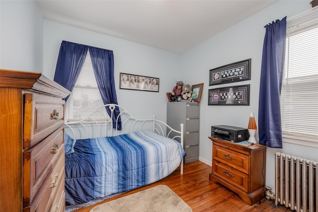 bedroom featuring dark hardwood / wood-style flooring and radiator heating unit