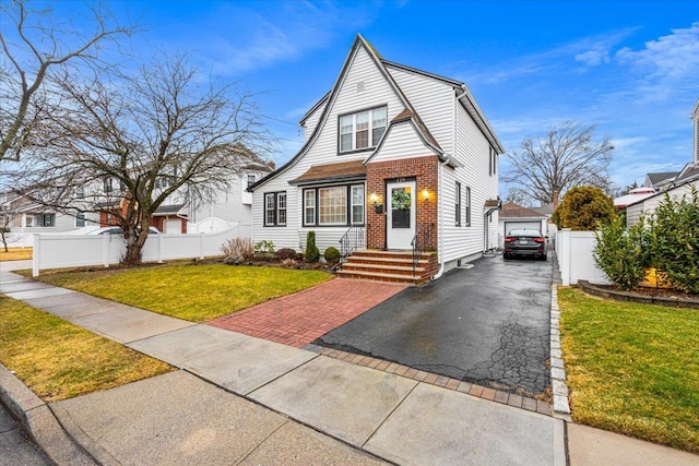 view of front facade with a garage, an outdoor structure, and a front yard