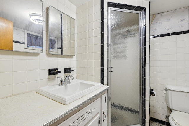 bathroom with vanity, toilet, tile walls, and an enclosed shower