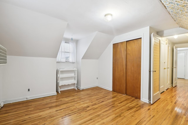 bonus room with light wood-type flooring and lofted ceiling