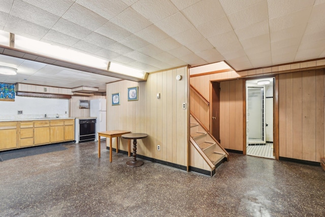 basement with sink, wood walls, and beverage cooler