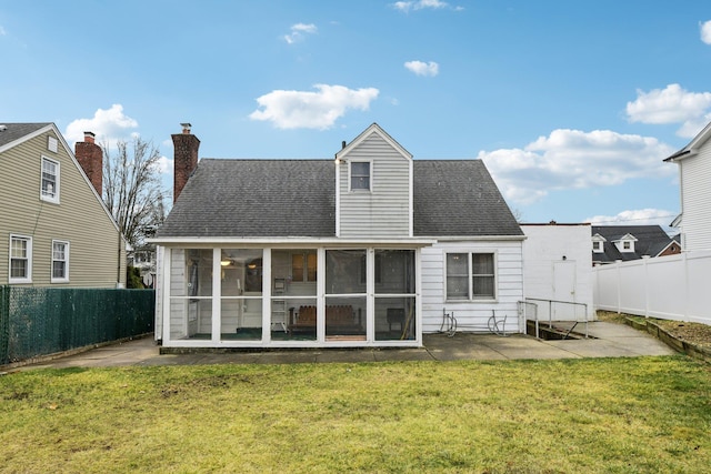 back of property featuring a lawn, a sunroom, and a patio