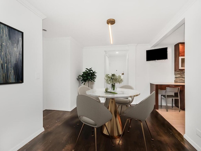 dining room featuring dark hardwood / wood-style floors and crown molding