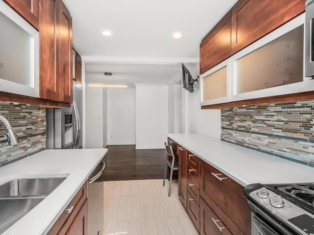 kitchen featuring stainless steel appliances, decorative backsplash, and sink