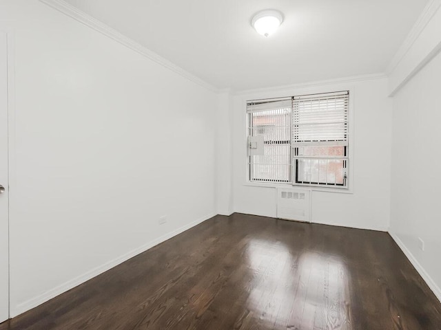 empty room with crown molding and dark hardwood / wood-style floors