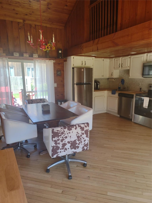 1139 State Route 17b, Mongaup Valley, NY 12762 - kitchen with appliances with stainless steel finishes, light wood-style floors, wood ceiling, decorative backsplash, and hanging light fixtures