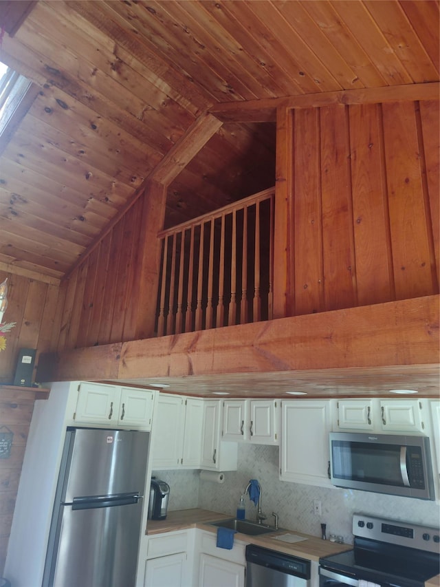 1139 State Route 17b, Mongaup Valley, NY 12762 - kitchen featuring stainless steel appliances, wooden ceiling, wood walls, vaulted ceiling, and white cabinets