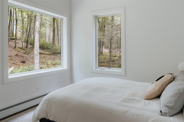 bedroom with baseboard heating and multiple windows