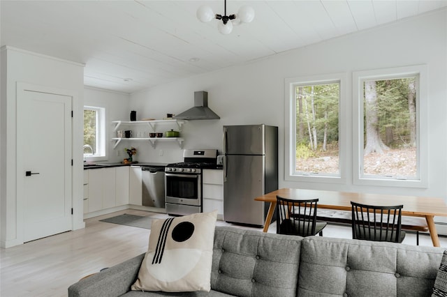 kitchen with white cabinetry, light hardwood / wood-style floors, wooden ceiling, stainless steel appliances, and wall chimney range hood