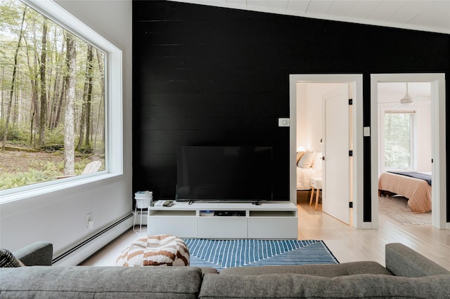 living room featuring vaulted ceiling, light hardwood / wood-style floors, and a baseboard radiator