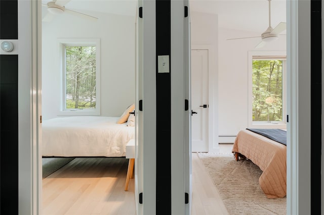 bedroom with ceiling fan, lofted ceiling, light hardwood / wood-style flooring, and a baseboard radiator