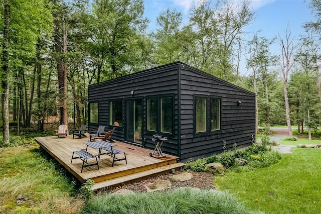 rear view of property featuring a wooden deck and a yard