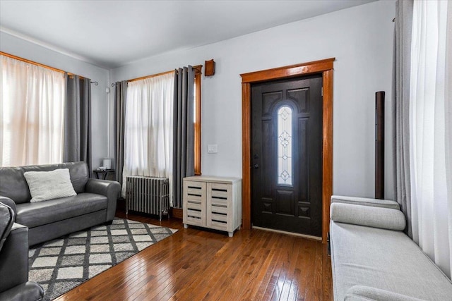 entrance foyer featuring dark wood-type flooring and radiator heating unit