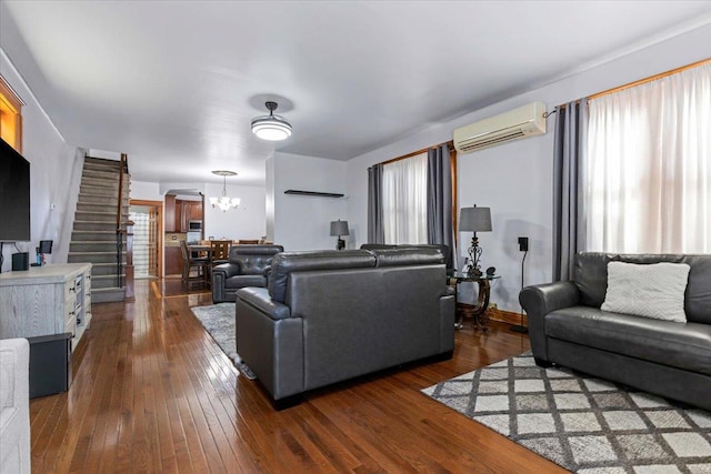 living room featuring dark hardwood / wood-style flooring, a wall mounted air conditioner, and an inviting chandelier