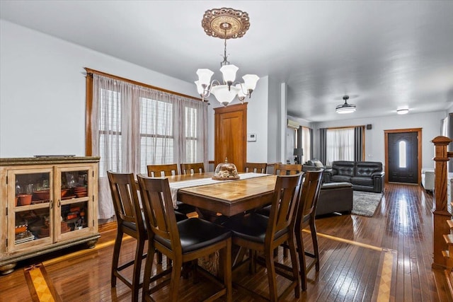 dining area with an inviting chandelier and dark wood-type flooring