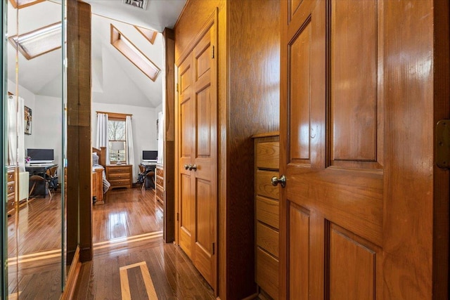 hall featuring vaulted ceiling and dark hardwood / wood-style floors