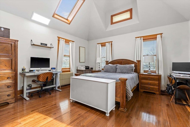 bedroom with lofted ceiling with skylight, radiator, hardwood / wood-style floors, and multiple windows