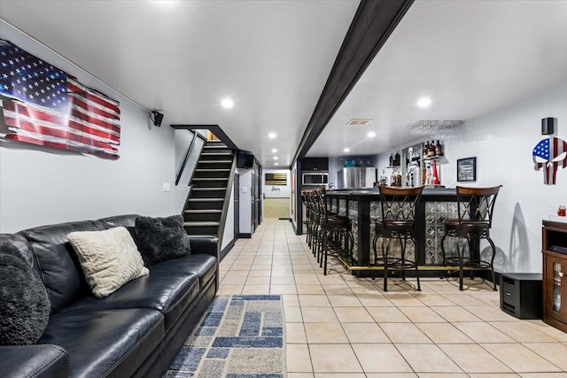 bar featuring fridge and light tile patterned floors