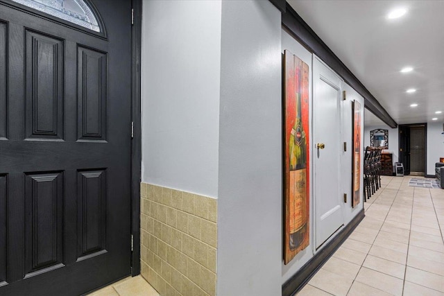 hallway with tile walls and light tile patterned floors