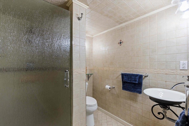 bathroom featuring crown molding, a shower with door, tile walls, tile patterned flooring, and toilet