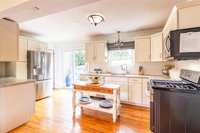 kitchen with tasteful backsplash, stainless steel appliances, sink, and hanging light fixtures