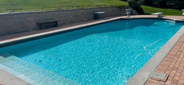 view of pool with a yard