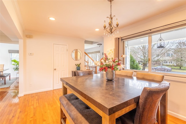 dining area with ornamental molding, a chandelier, and light hardwood / wood-style flooring