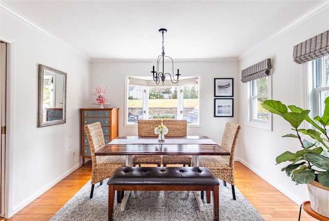 dining area with ornamental molding, hardwood / wood-style floors, and an inviting chandelier