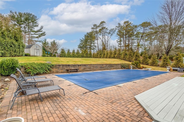 view of swimming pool with a patio, a yard, and a shed