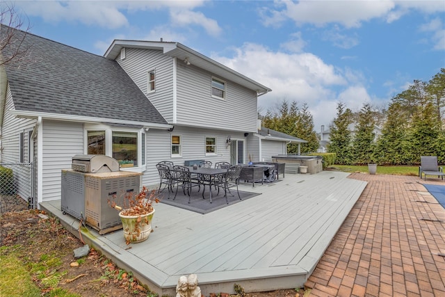 wooden deck featuring a hot tub and exterior kitchen