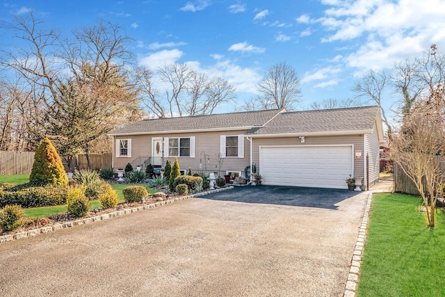 ranch-style house featuring a front yard and a garage