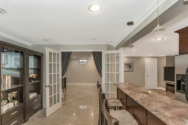 kitchen with light stone counters, pendant lighting, dark brown cabinets, and french doors