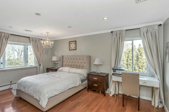 bedroom with hardwood / wood-style flooring, a baseboard heating unit, crown molding, and a notable chandelier